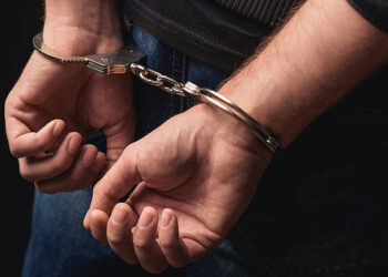 Close up of male hands in bracelets behind back