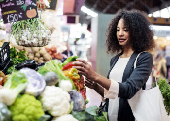 Woman buying vegetables in market